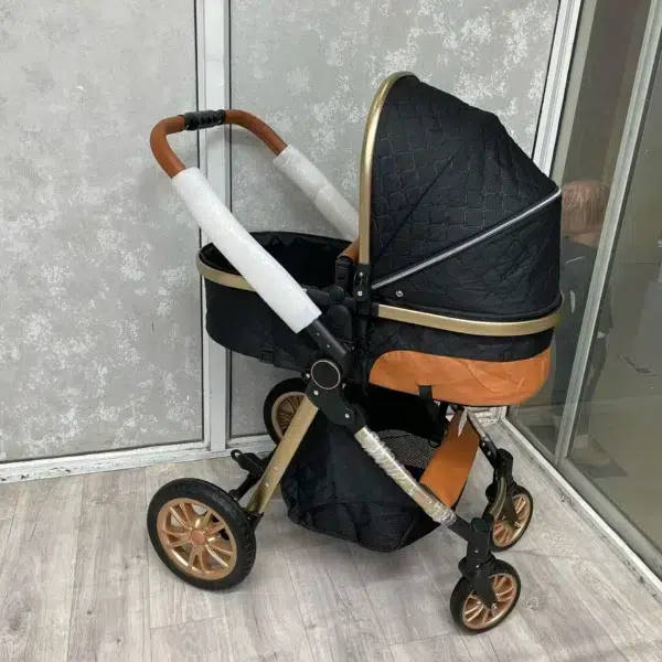A stylish 3-in-1 premium baby stroller in black and gold, featuring a quilted design, adjustable handlebar, and durable wheels. Includes a detachable infant car seat for versatile use. Perfect for comfort, safety, and convenience.