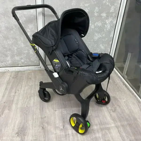 A sleek 4-in-1 baby stroller in black, featuring a secure car seat, carry cot, and adjustable handle. Designed for comfort, safety, and easy mobility.