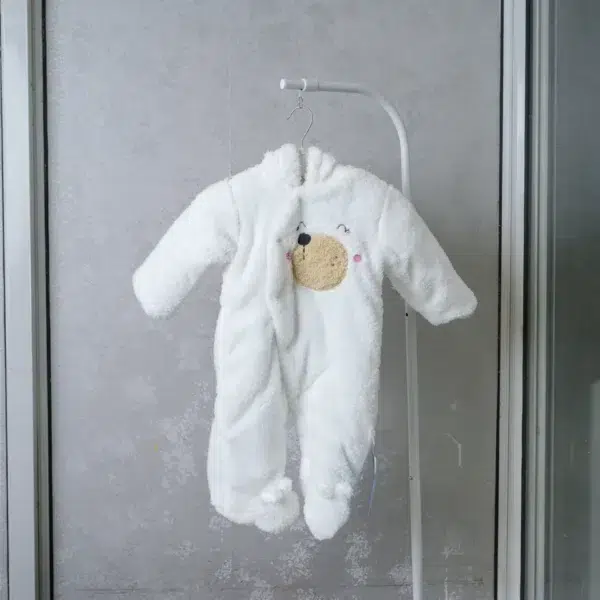 fleece baby romper with hood and animal ears, featuring paw print knee accents, front zipper, and snap-button leg openings, displayed on a flat surface.