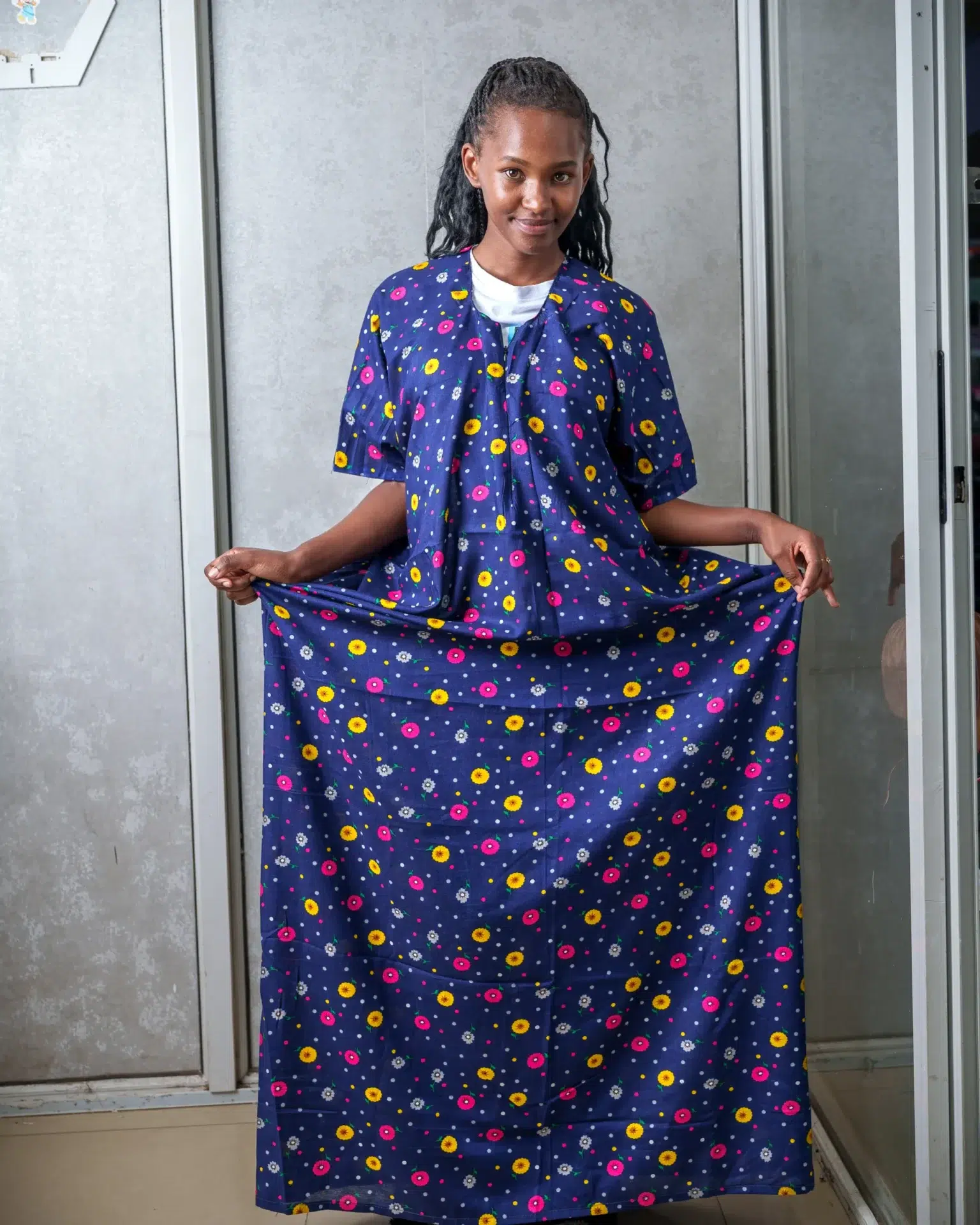 Woman modeling a navy blue nursing dera featuring a colorful floral print, highlighting the garment’s modest coverage and relaxed fit.